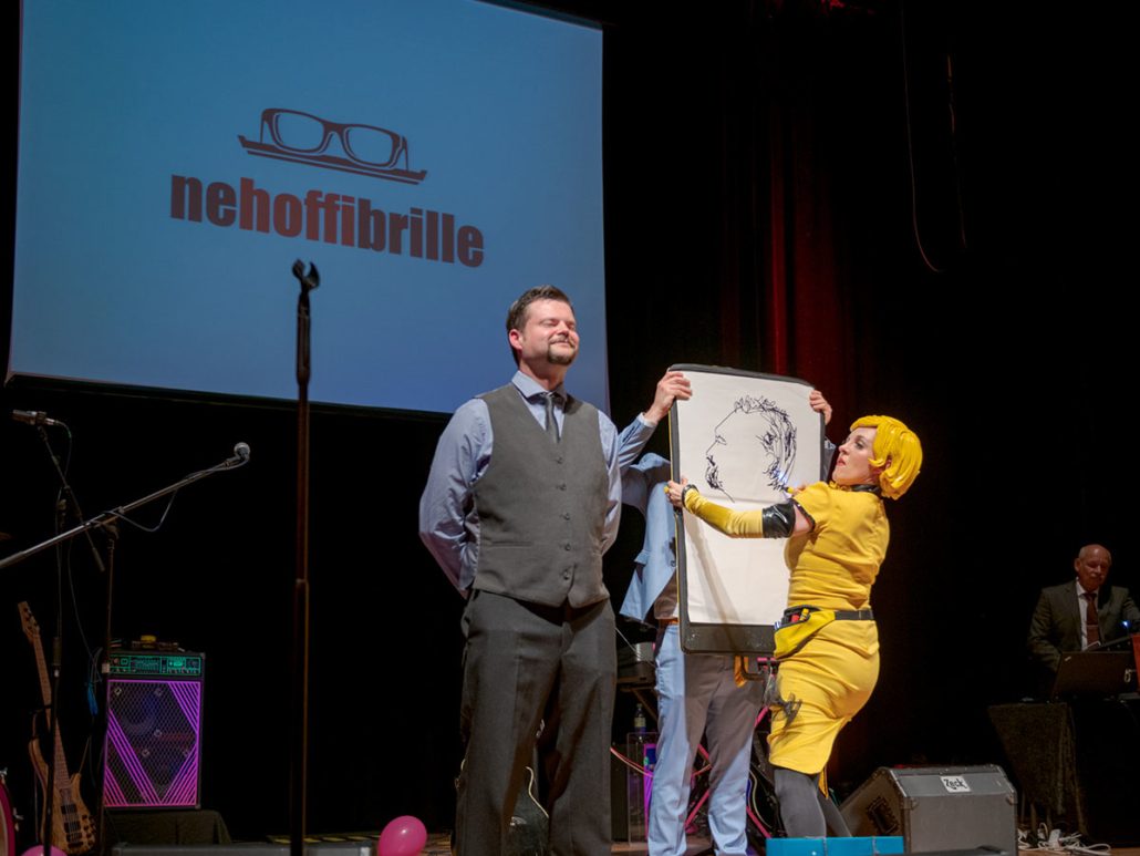Karikatur auf der Bühne beim 23. brillenball 2018 von hoffmann und brillen