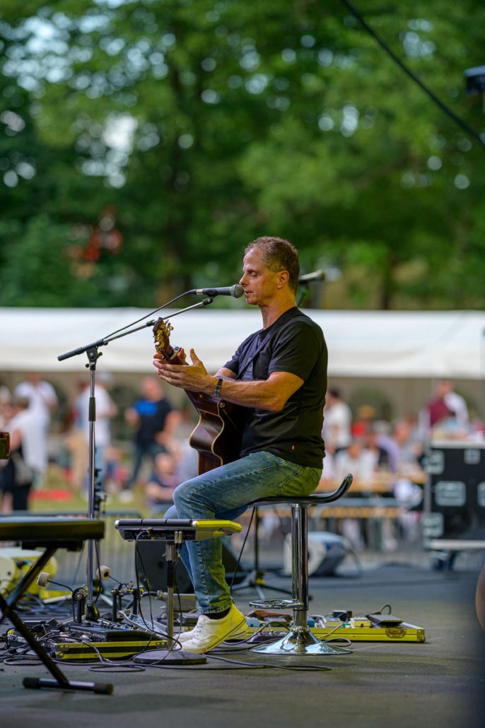 Musiker mit Gitarre auf dem Barhocker beim brillenball OpenAir 2021