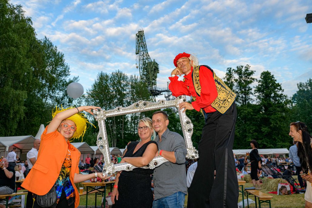 Fotoaktion mit Bilderrahmen und Stelzenläufer beim brillenball OpenAir 2021