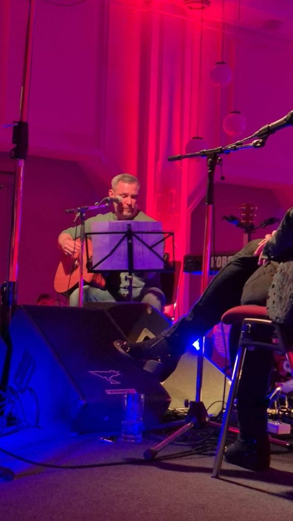 Musiker mit Gitarre und Notenständer beim Songwriter-Circle im Haus Schwärzetal